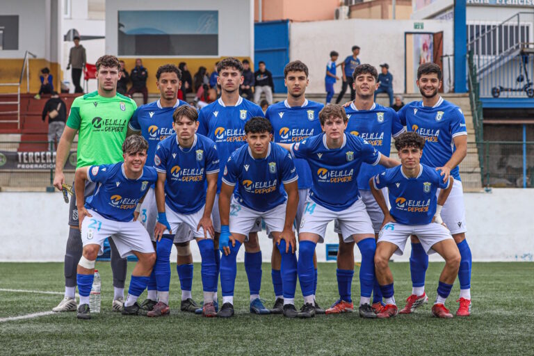 Equipo juvenil de fútbol con camisetas azules en el campo