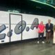 Tres hombres posando junto a un autobús de la COA en Melilla