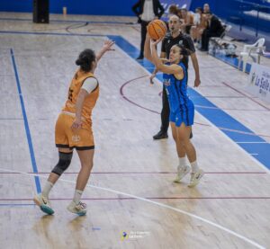 Jugadora del equipo La Salle lanzando el balón en un partido de baloncesto