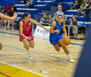 Jugadora de baloncesto en acción durante un partido competitivo.