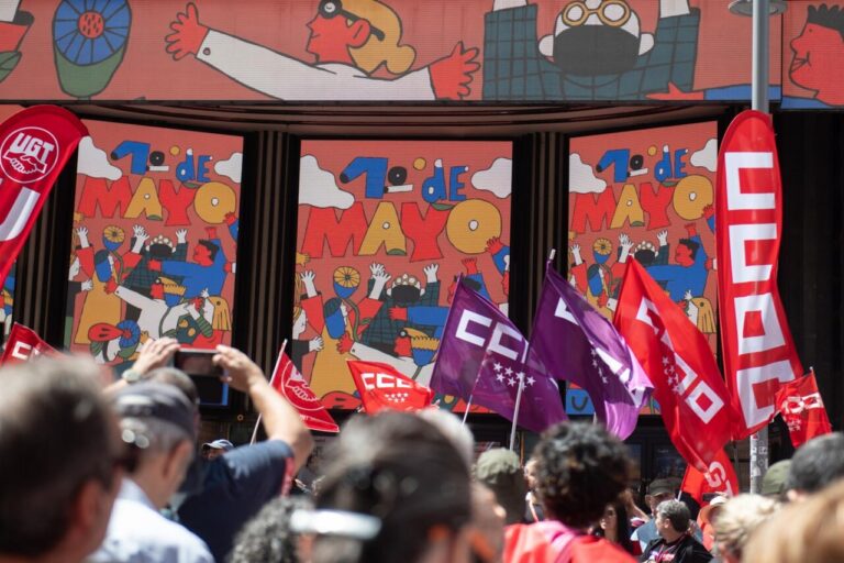 Multitud de personas en una manifestación en Madrid con banderas de sindicatos.