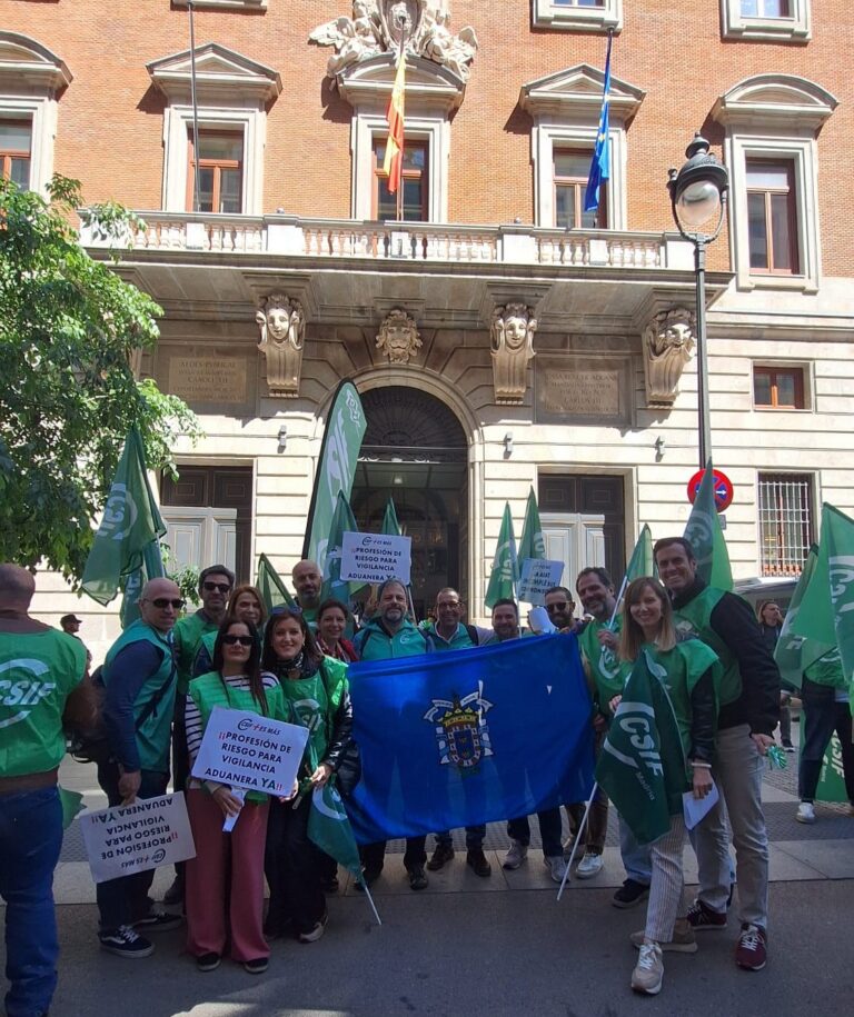 Grupo de personas en una manifestación con banderas verdes y pancartas.