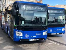 Blue city buses parked on a street; the front bus shows route 4 with destination 'Universidad' and a second bus beside it labeled 'Tesorillo'