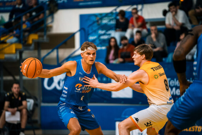 Jugadores de baloncesto compitiendo en un partido intenso en Melilla