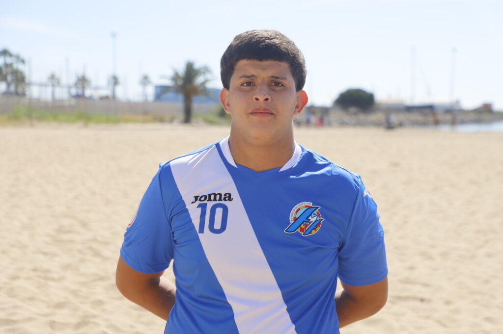 Jugador de fútbol playa de Melilla con camiseta azul en la arena