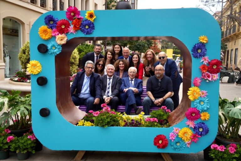 Grupo de personas posando en un marco decorado con flores en Melilla