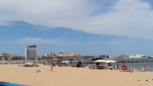 Playa de Melilla con bañistas y sombrillas bajo el sol