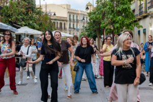 Grupo de mujeres bailando en una calle durante un festival