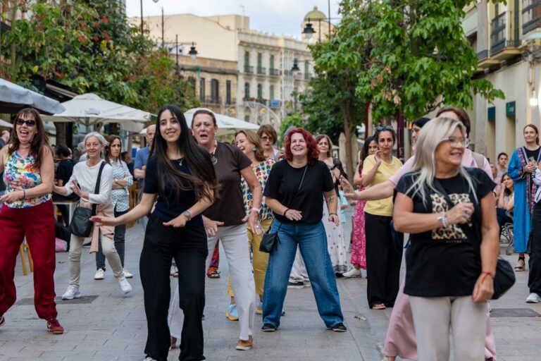 Grupo de mujeres bailando en una calle durante un festival