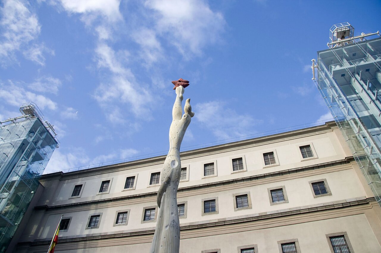 Vista del Museo Reina Sofía con escultura y cielo azul