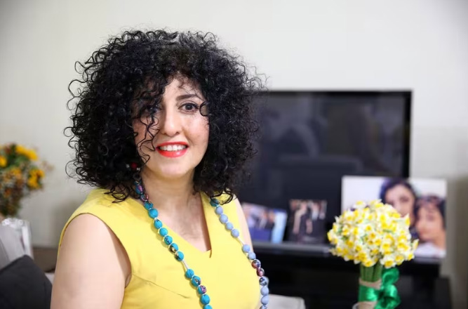 Narges Mohammadi, Premio Nobel de la Paz, sonriendo con flores en mano.