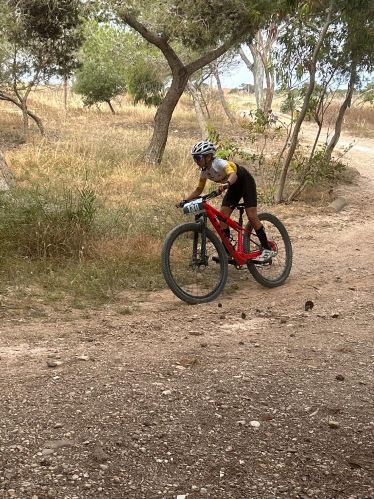 Niño compitiendo en bicicleta de montaña en un circuito