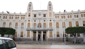 Vista del Palacio de la Asamblea en Melilla con banderas y árboles