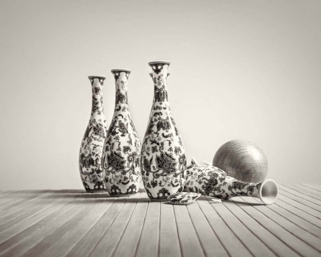 Three tall ceramic vases with intricate floral patterns on a wooden table.