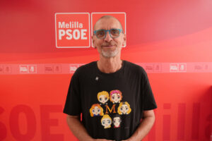 Persona con camiseta de personajes en evento del PSOE en Melilla