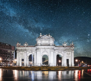 Puerta de Alcalá iluminada bajo un cielo estrellado en Madrid