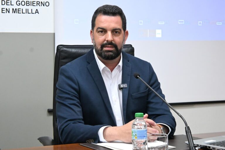 Hombre con barba sentado en una mesa durante una reunión del gobierno en Melilla