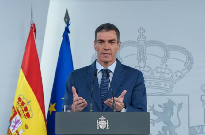 Pedro Sánchez dando una rueda de prensa junto a banderas de España y la UE