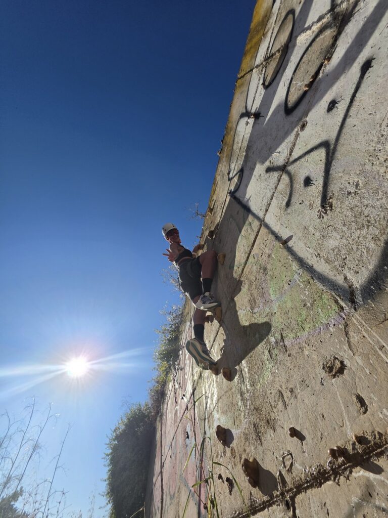 Participante escalando en un taller de iniciación a la escalada deportiva