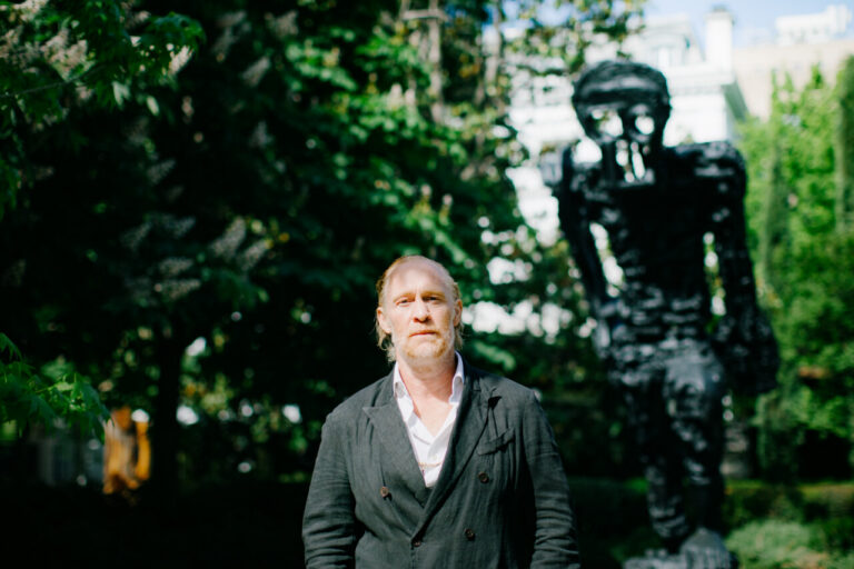 Escultor Thomas Houseago en el jardín de Banca March junto a su escultura.