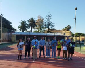 Grupo de campeones del Torneo UNED Melilla en la pista de tenis