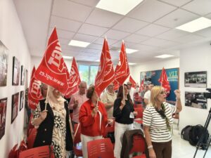 Miembros de UGT y CCOO levantan banderas en la celebración del 1 de mayo en Melilla.