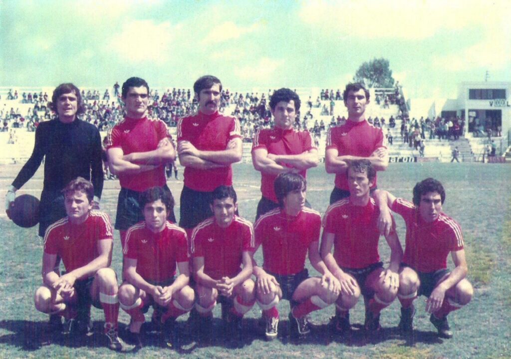 Equipo de fútbol en camiseta roja posando en el campo
