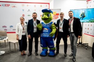 Grupo de personas en el Sports Summit de Madrid con mascota de los Juegos del Agua