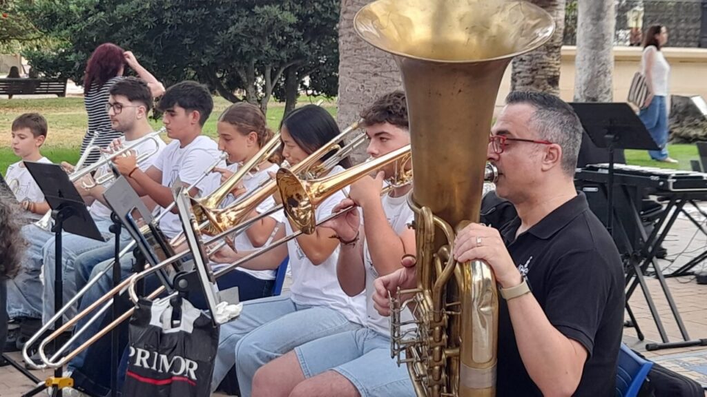 Músicos de la Orquesta Joven Ciudad de Melilla tocando instrumentos en un recital