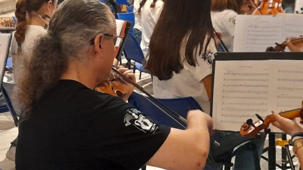 Músico tocando el violín en un concierto de orquesta juvenil