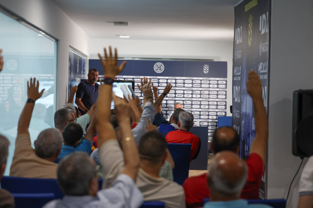 Socios levantando la mano durante la asamblea de la U.D. Melilla