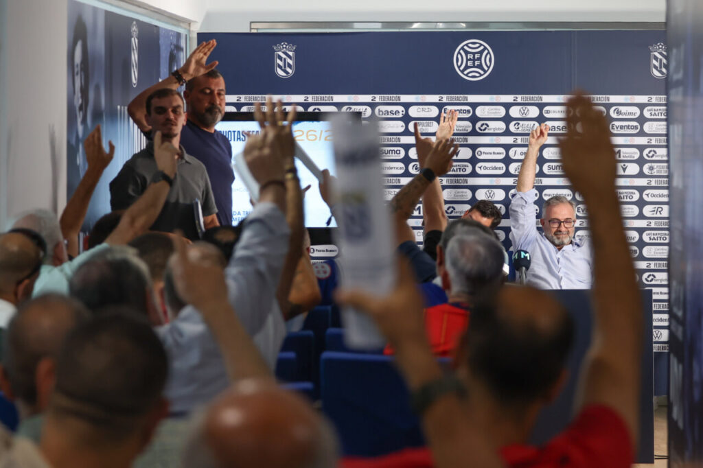Socios de la U.D. Melilla levantan la mano durante la asamblea