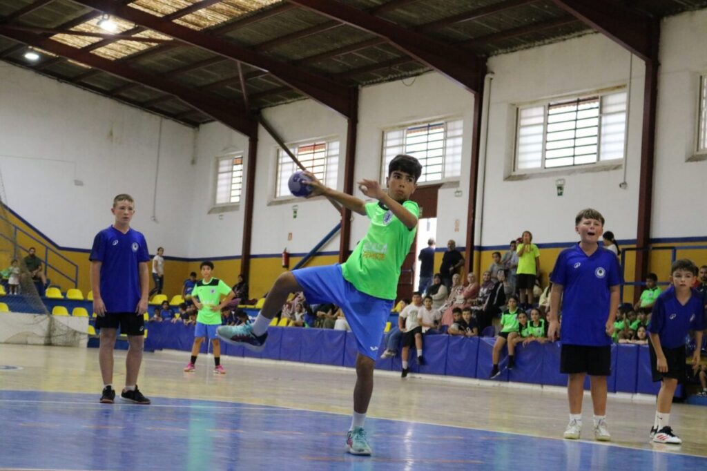 Niño lanzando un balón de balonmano en un partido juvenil