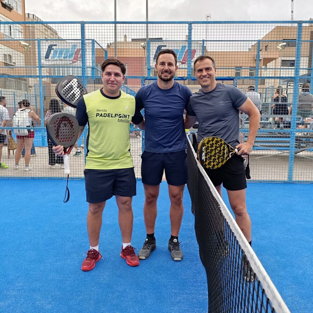 Tres jugadores posando en la cancha de pádel durante el torneo