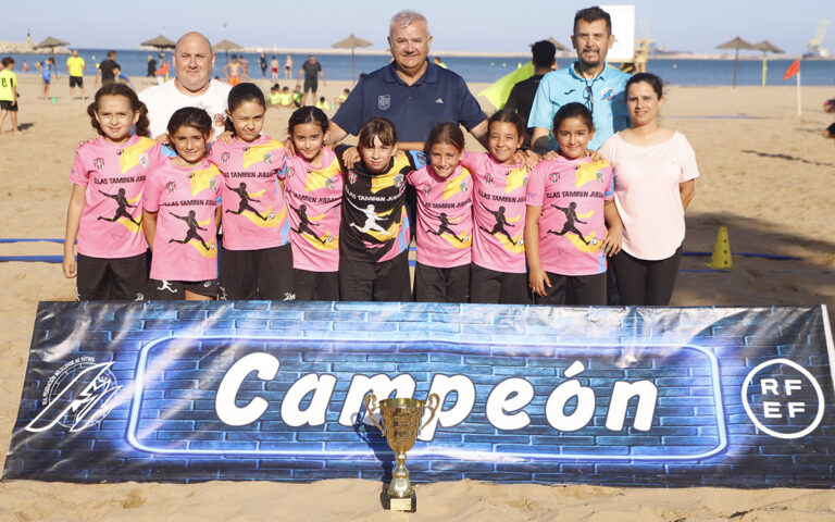 Equipo de niñas campeonas con trofeo en la playa