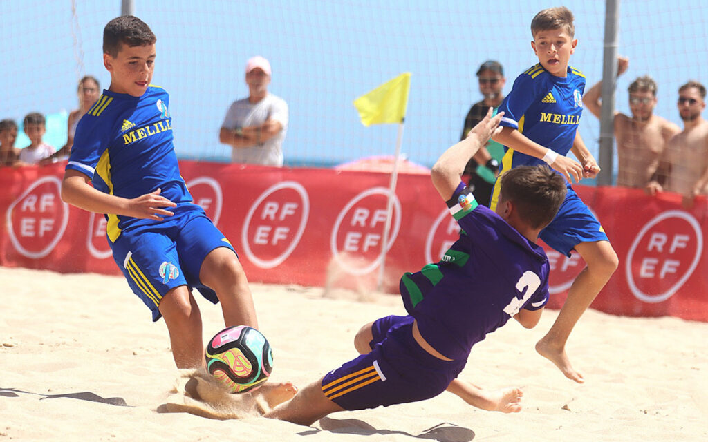 Niños jugando al fútbol en la playa durante el torneo CESA en Melilla