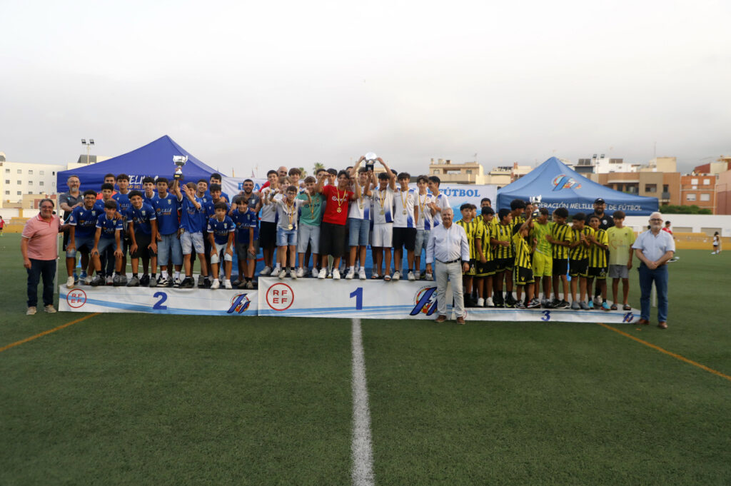 Equipo de fútbol juvenil en ceremonia de premiación con trofeo