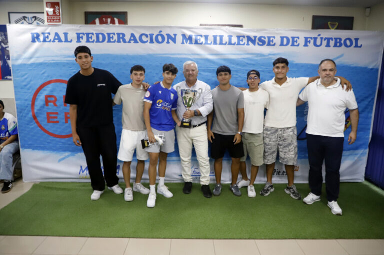 Grupo de jóvenes recibiendo trofeos en la Real Federación Melillense de Fútbol