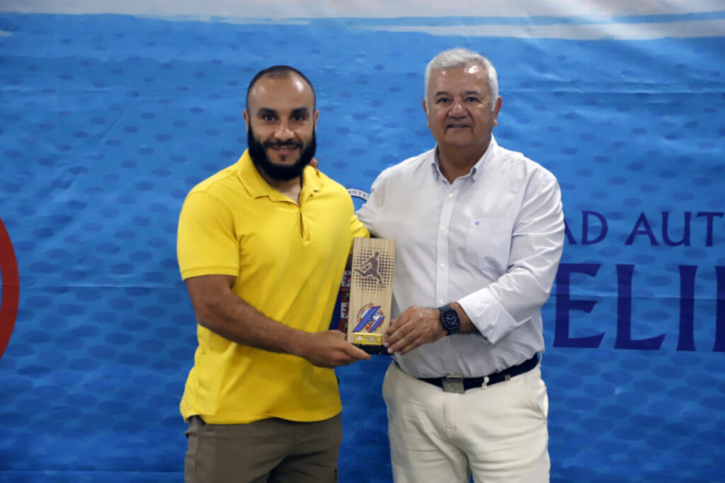 Dos hombres sosteniendo un trofeo en un evento deportivo en Melilla