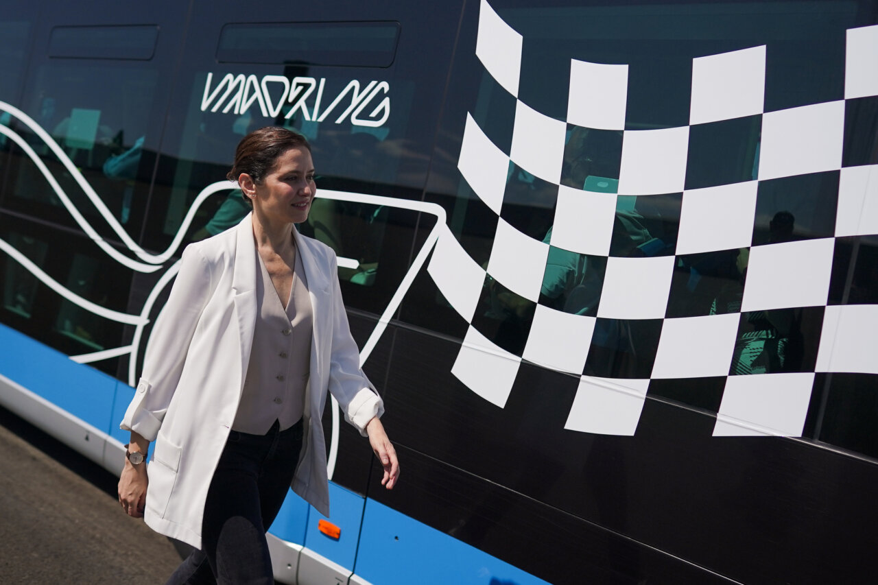 Persona caminando junto a un autobús con diseño de circuito de F1