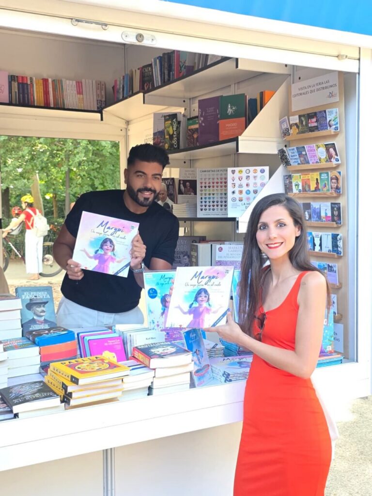 Juan Heredia Urbano y una mujer sosteniendo libros en la Feria del Libro de Madrid