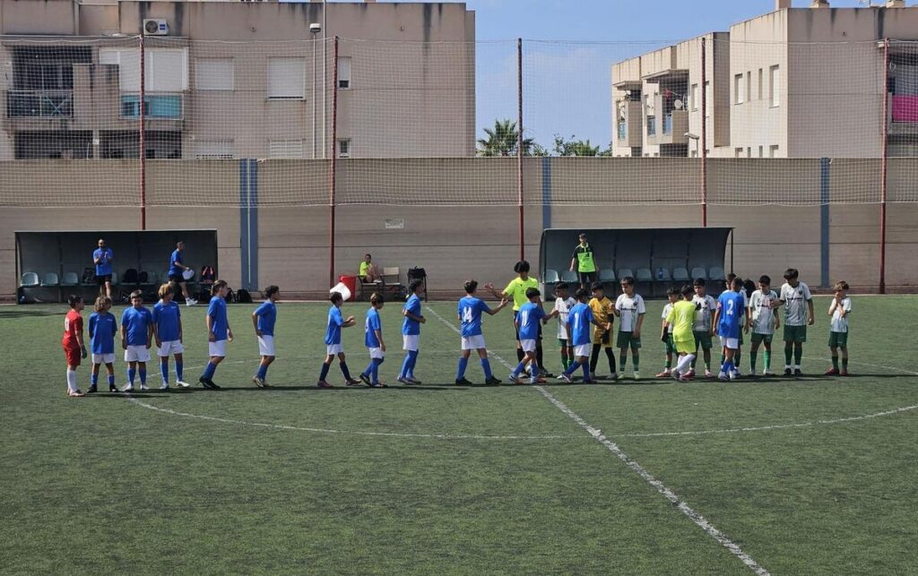 Jugadores de fútbol saludándose en el campo durante el torneo Youth Supercup