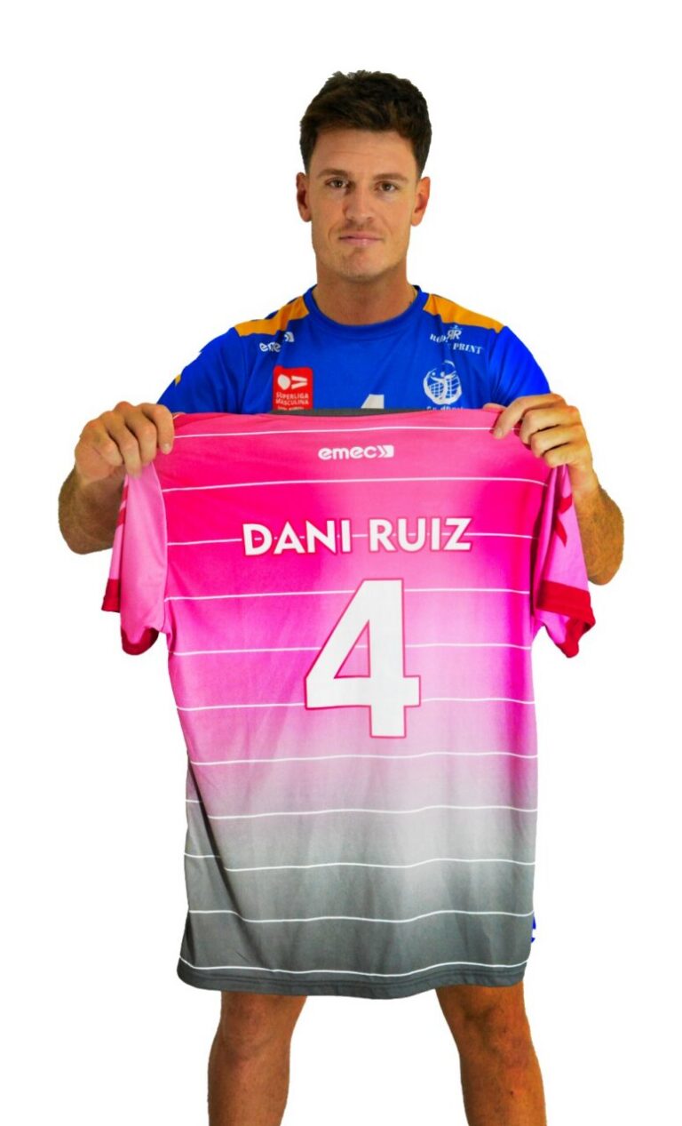 Man in a blue jersey holds up a pink gradient sports jersey showing the name 'DANI-RUIZ' and the number 4 in white.