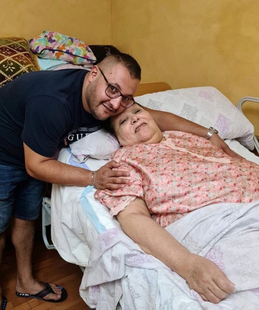 Hijo abrazando a su madre en una cama, momentos emotivos.