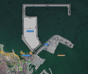 Aerial map of a harbor showing a large dock complex with an L-shaped breakwater and an expansion area by the water, with surrounding marina.