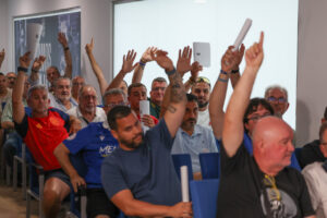 Socios de la U.D. Melilla levantando la mano durante la asamblea