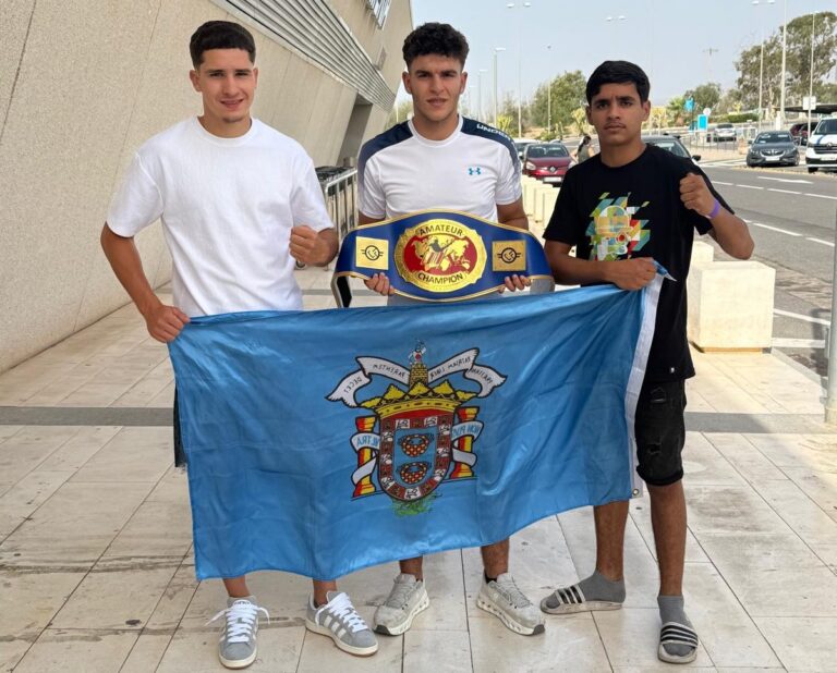 Badi Lahfa y compañeros con cinturón de campeón y bandera
