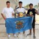 Badi Lahfa y compañeros con cinturón de campeón y bandera