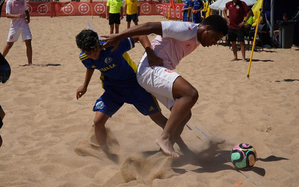 Jugadores de fútbol playa compitiendo en la arena durante un partido