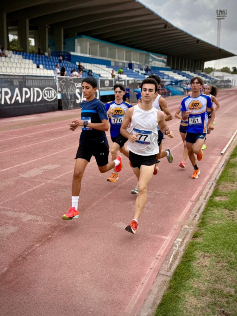 Jóvenes atletas compitiendo en una carrera de 800 metros en Melilla.